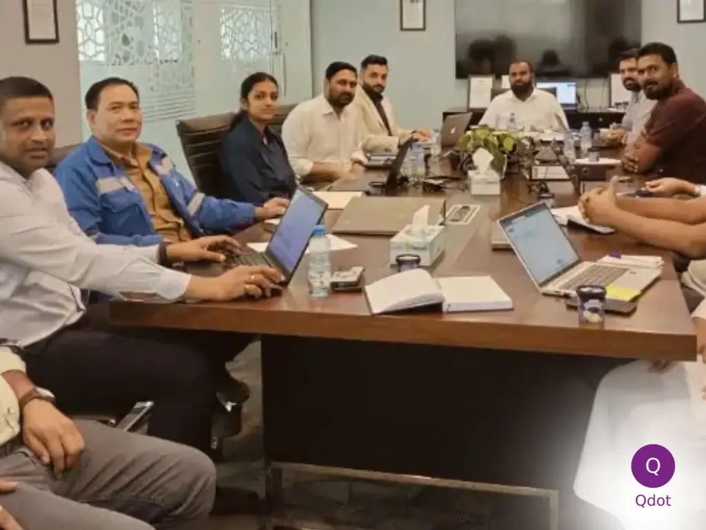 A professional ISO certification consultant smiling confidently while holding a clipboard, with a team collaborating in the background, symbolizing effective guidance and implementation of management system standards.