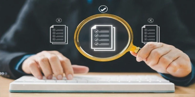 Professional reviewing ISO 9001 documents with a magnifying glass to highlight mandatory quality checklist items