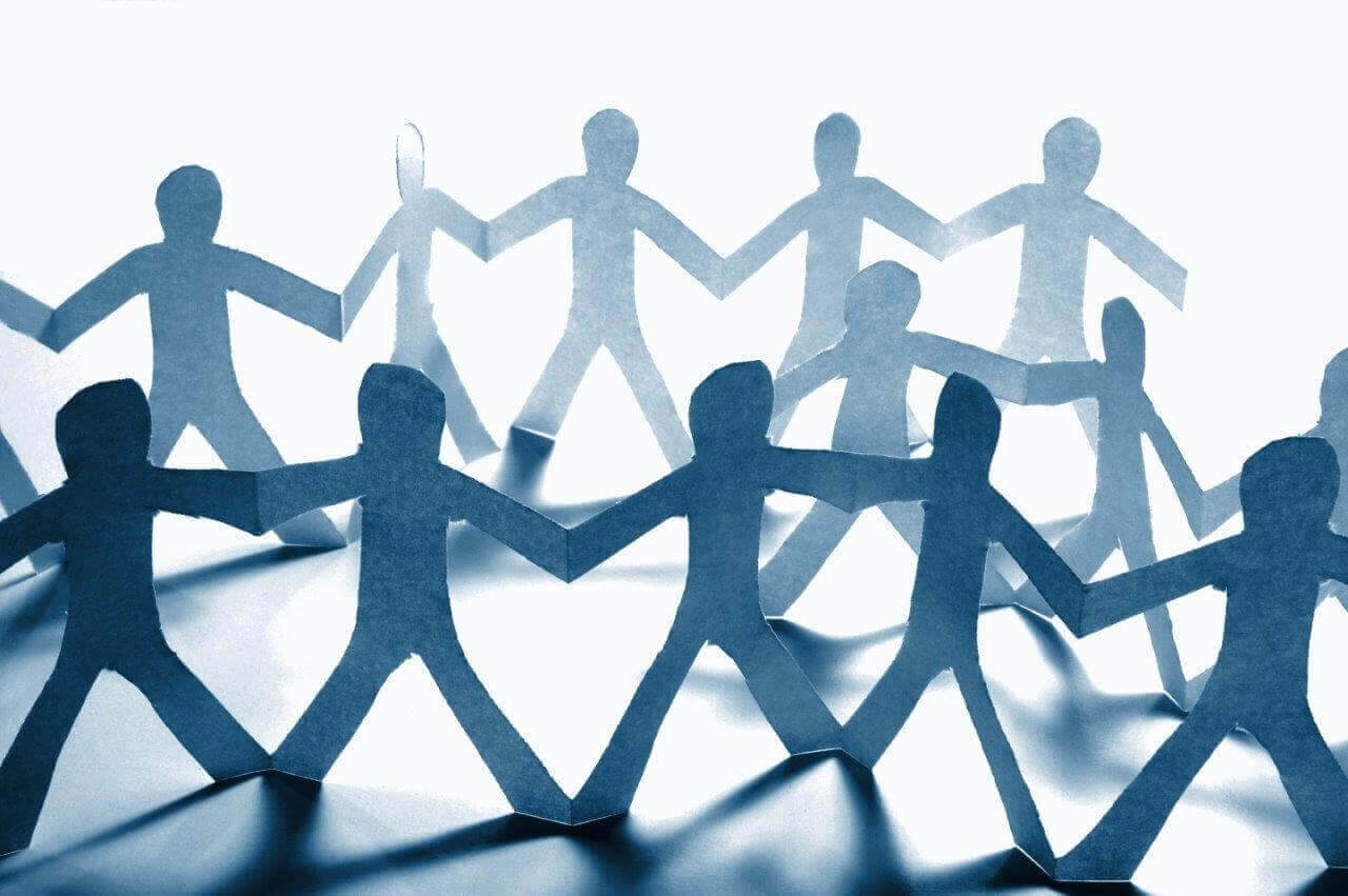 A close-up image of interconnected paper cutout figures holding hands in a circular formation, symbolizing unity and teamwork. This visual representation aligns with the Sedex Smeta Audit in Pakistan, highlighting collaboration and commitment to ethical business practices.