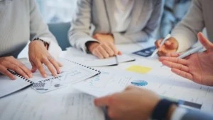 Business professionals reviewing documents during ISO certification audit and compliance discussion