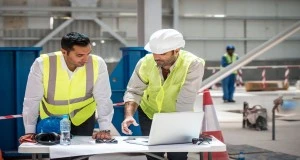 Safety team reviewing ISO 45001 audit findings and workplace documents during an on-site assessment in the UAE 